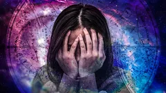 顔を手で覆う女性と、背後の星座盤の幻想的な背景
