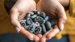 両手に数字が書かれた小石をすくっている様子