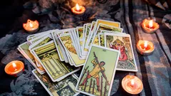 キャンドルに囲まれた布の上に広げたタロットカード
